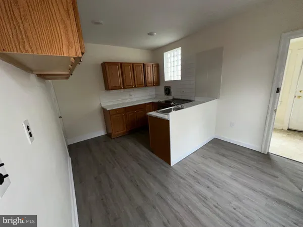 a kitchen with a sink and wooden floor