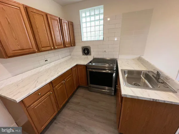 a kitchen with granite countertop a sink a stove and cabinets