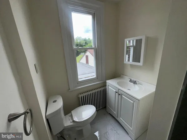 a bathroom with a sink toilet and window