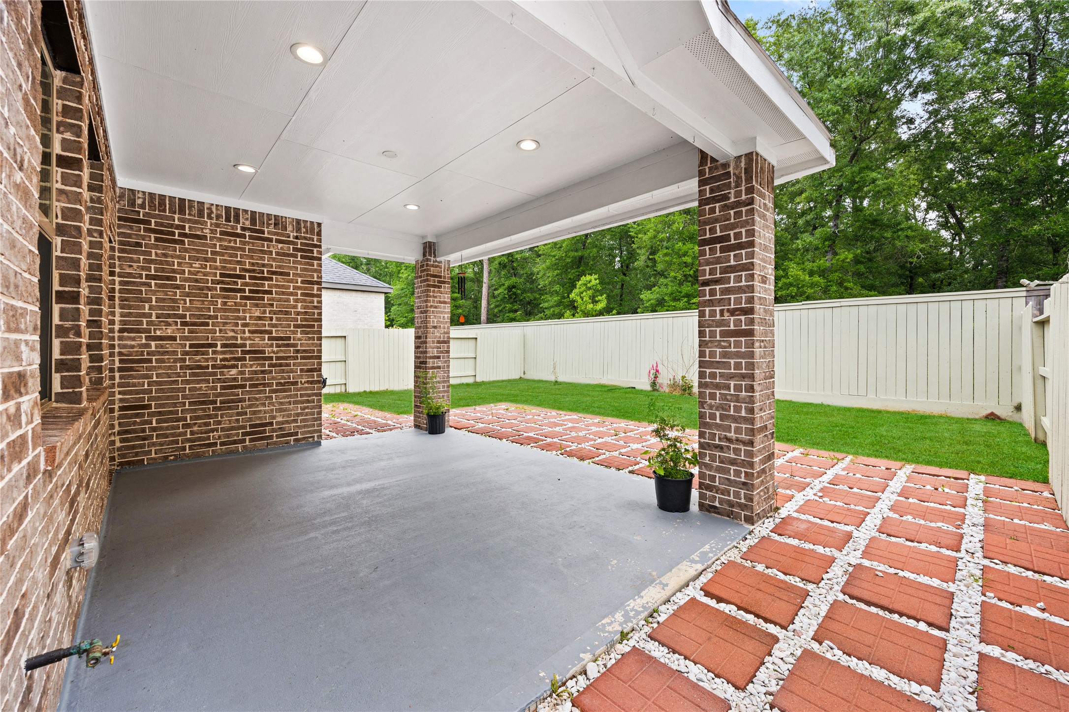 10636 Wild Chives Conroe, TX 77385 - Photo 24 of 29 a view of a patio with table and chairs with wooden fence and plants