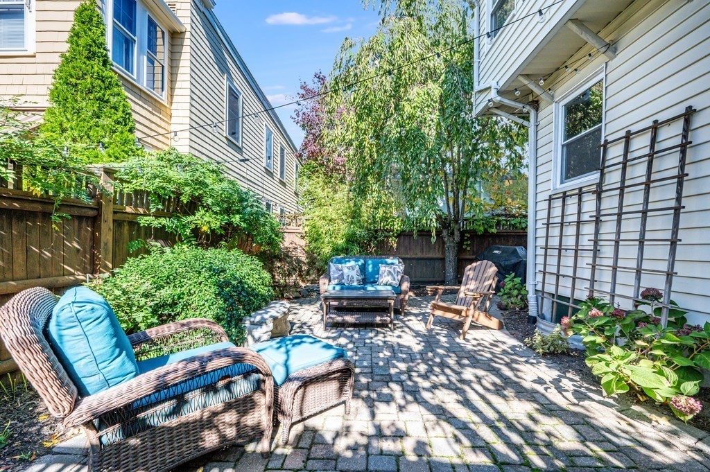 98 Reed Street Cambridge, MA 02140 - Photo 29 of 32 front view of a house with a chairs and table in a patio