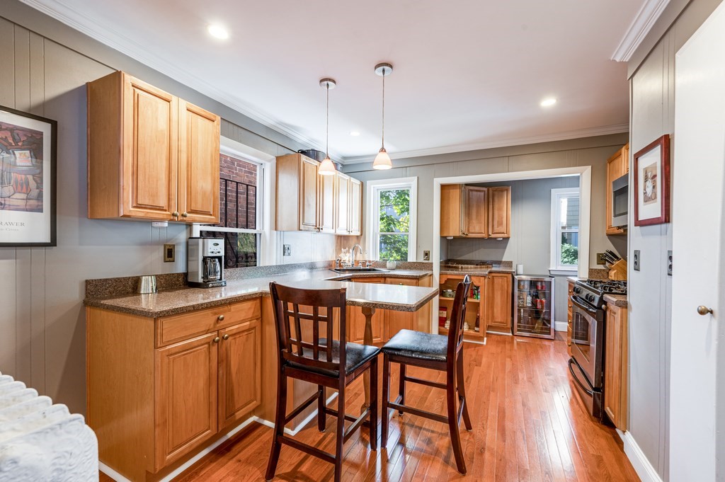 98 Reed Street Cambridge, MA 02140 - Photo 10 of 32 a open kitchen with stainless steel appliances granite countertop a stove a sink dishwasher a dining table and chairs with wooden floor
