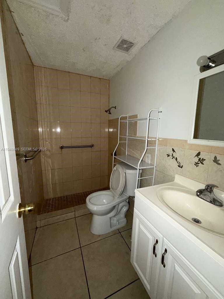 12241 Southwest 268th Street, Unit 2 Homestead, FL 33032 - Photo 2 of 5 a bathroom with a sink a toilet and a shower