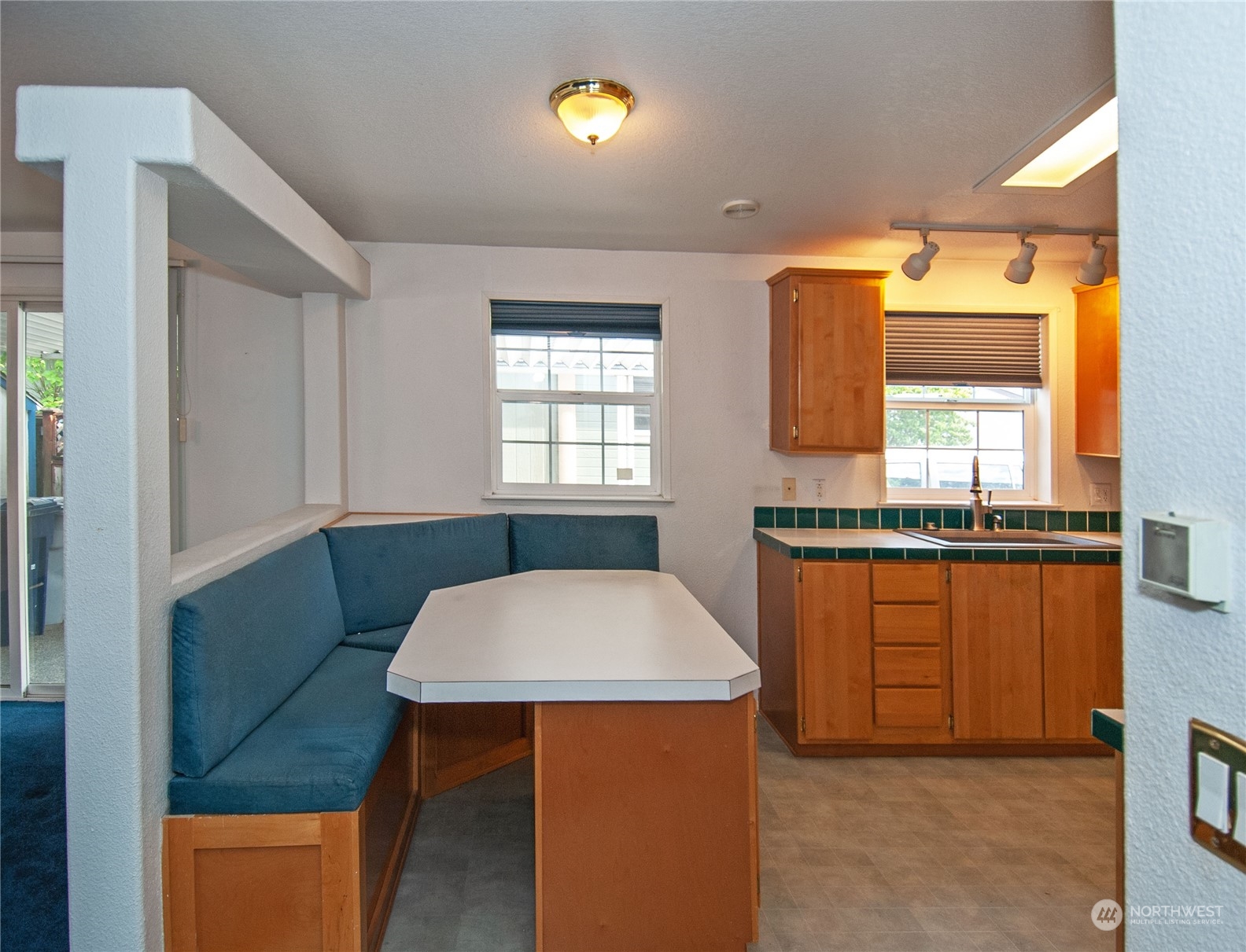 15400 Southeast 155th Place, Unit 12 Renton, WA 98058 - Photo 8 of 21 a kitchen with stainless steel appliances kitchen island granite countertop wooden cabinets a sink a stove a dining table and chairs