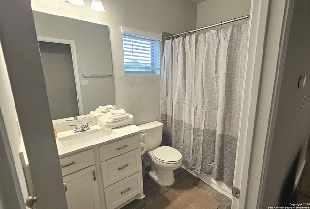 a bathroom with a granite countertop sink toilet and shower