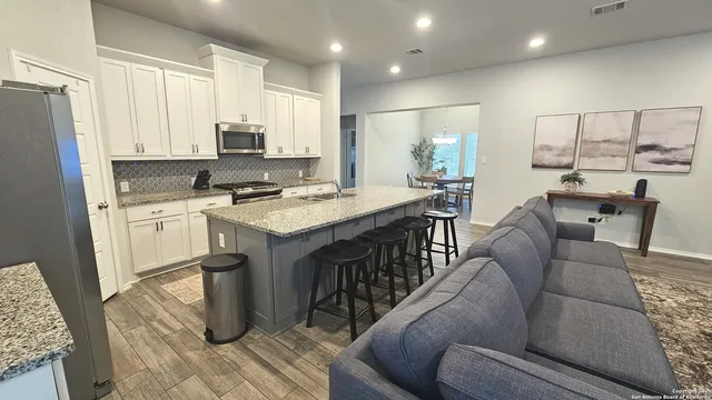a view of kitchen with stainless steel appliances granite countertop lots of counter top space