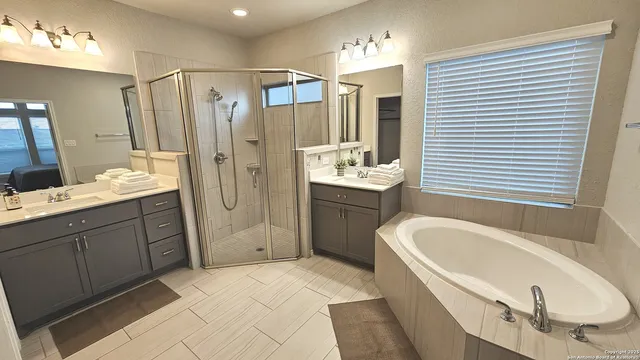 a bathroom with a tub sink and mirror