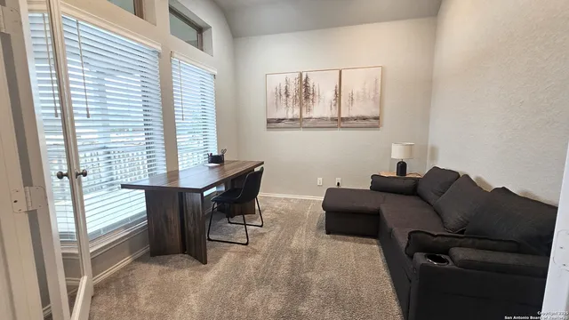 a view of a workspace with furniture and a window