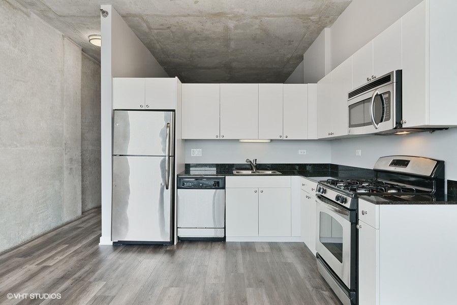 235 West Van Buren Street, Unit 4409 Chicago, IL 60607 - Photo 11 of 26 a kitchen with a white cabinets and white appliances