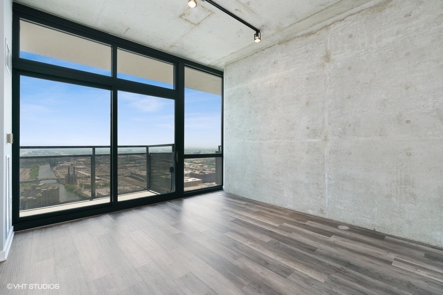235 West Van Buren Street, Unit 4409 Chicago, IL 60607 - Photo 8 of 26 a view of a room with wooden floor and iron stairs