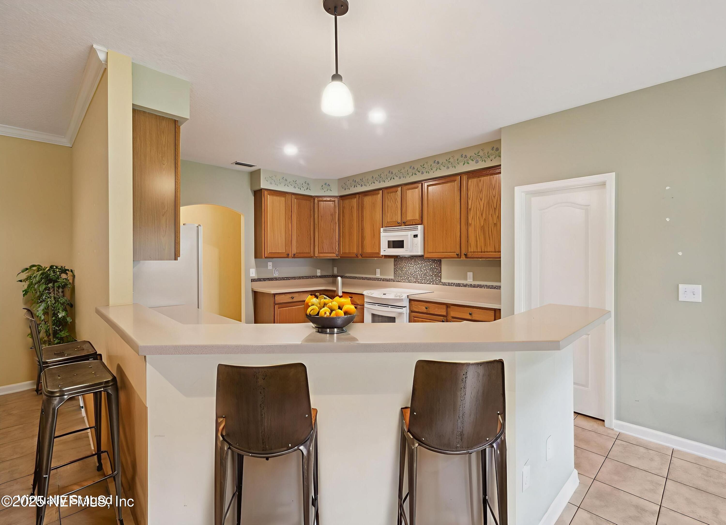 5802 Manning Cemetery Road Jacksonville, FL 32234 - Photo 21 of 117 a kitchen with stainless steel appliances a dining table chairs refrigerator and sink