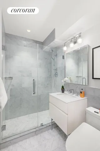 a bathroom with a sink a toilet and shower