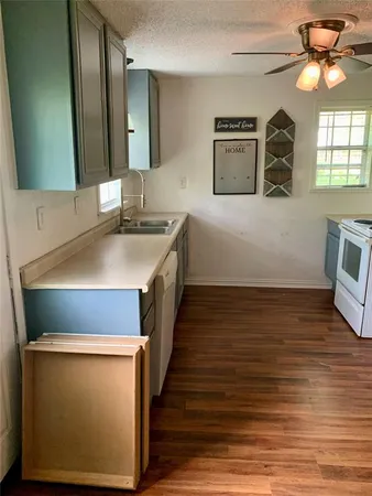 a kitchen with wooden floor and window