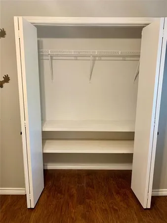 a view of walk in closet with empty racks