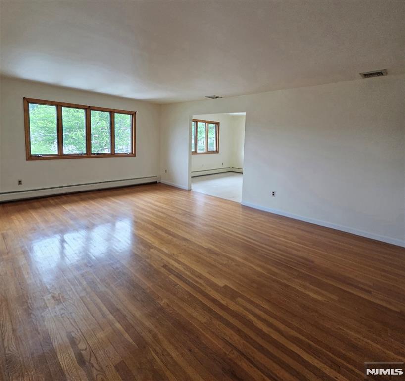 688 Day Avenue, Unit 2 Ridgefield, NJ 07657 - Photo 6 of 18 an empty room with wooden floor and windows