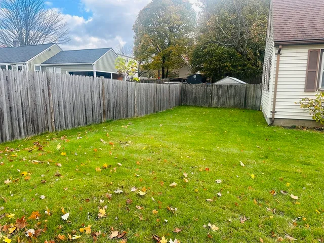 a view of a brick house with a large window and wooden fence