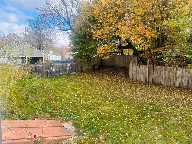 a view of a backyard with wooden fence