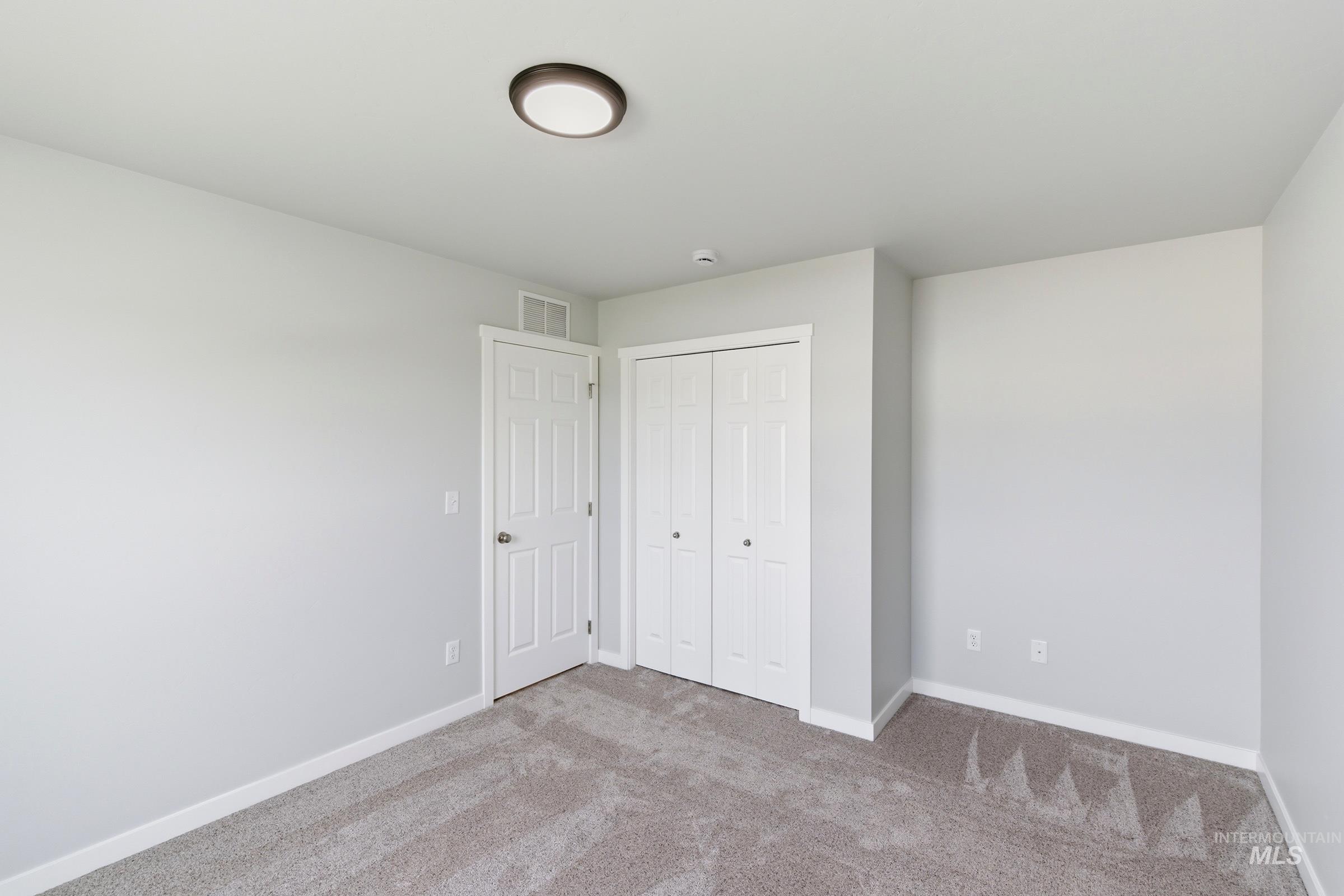 16558 Dunning Way Caldwell, ID 83607 - Photo 13 of 35 Neutral-toned room featuring light gray walls, plush gray carpeting, and white baseboards