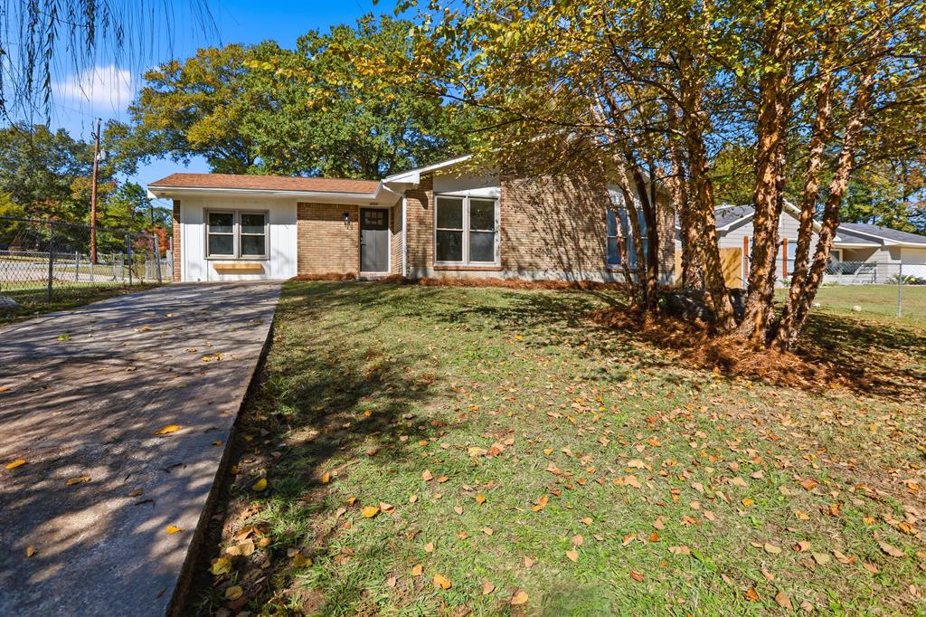 a view of house with backyard and trees
