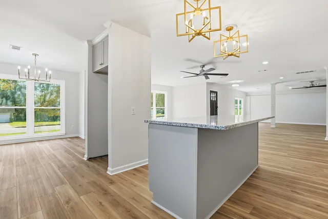 a view of a kitchen with wooden floor and a large window