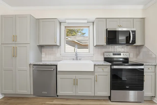 a kitchen with white cabinets stainless steel appliances and sink