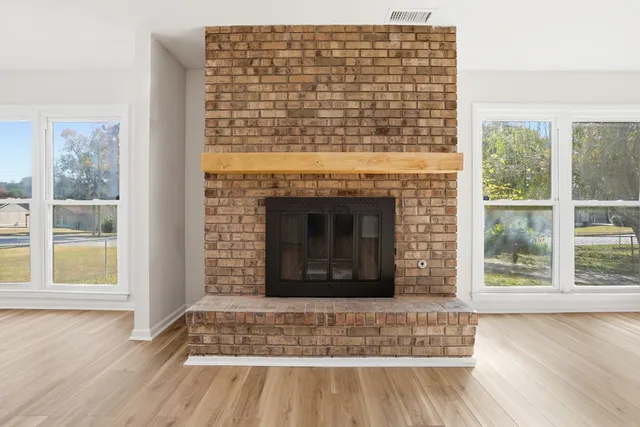 a living room with a fireplace and wooden floor