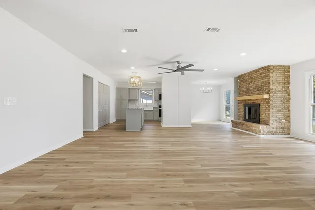 a view of empty room with wooden floor and fireplace