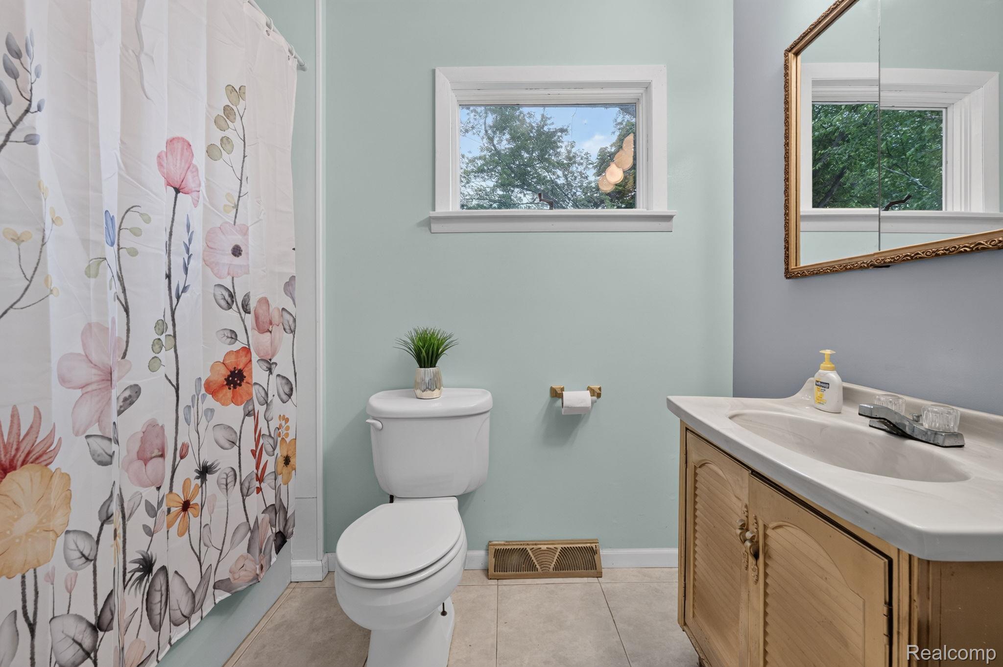 9288 Hilda Lane Flushing, MI 48433 - Photo 28 of 50 Bathroom featuring a single window, a toilet, a vanity with an integrated sink, a framed mirror, and tile flooring