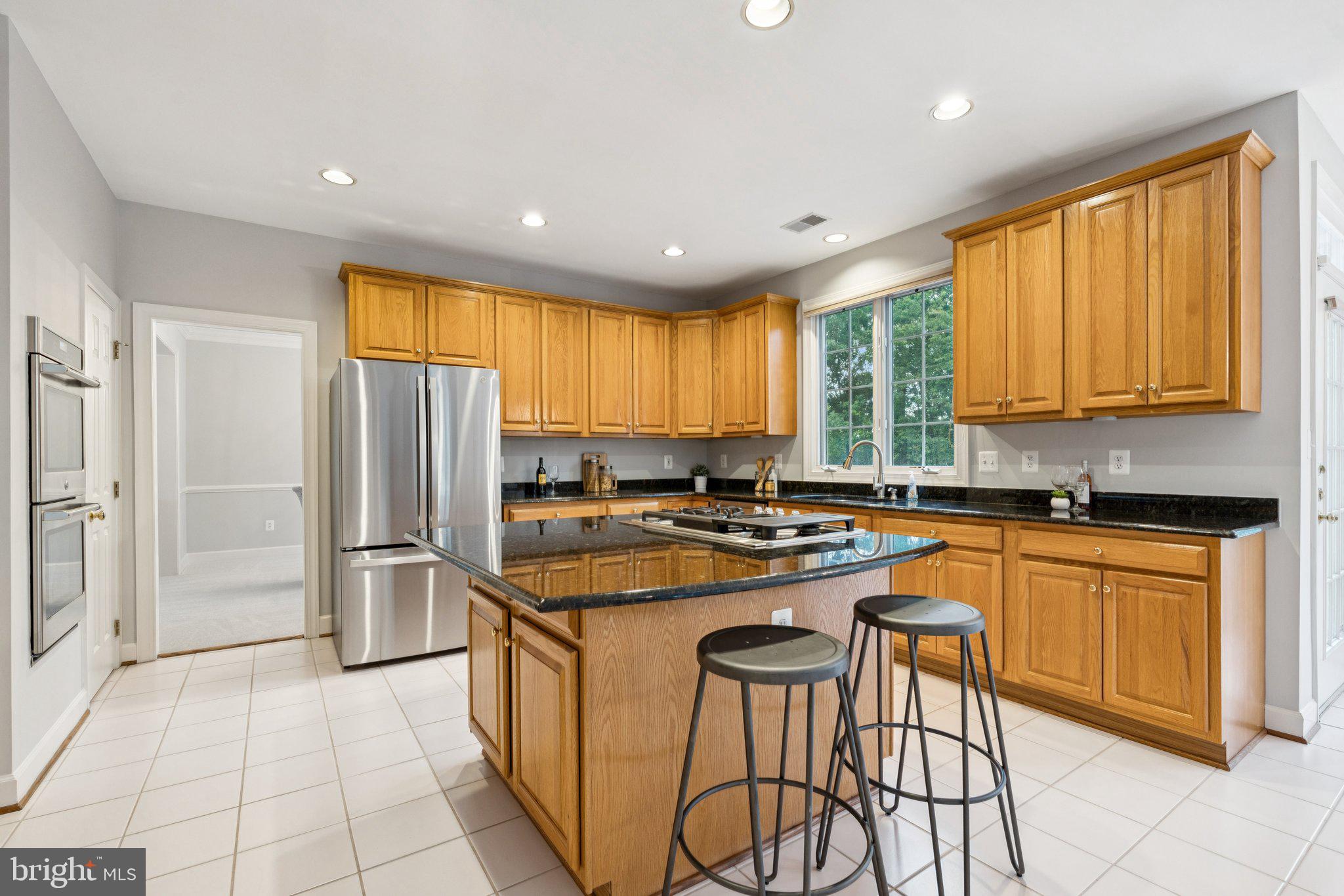 12213 Windsor Hall Way Herndon, VA 20170 - Photo 15 of 64 a kitchen with stainless steel appliances granite countertop a stove a sink a refrigerator and island