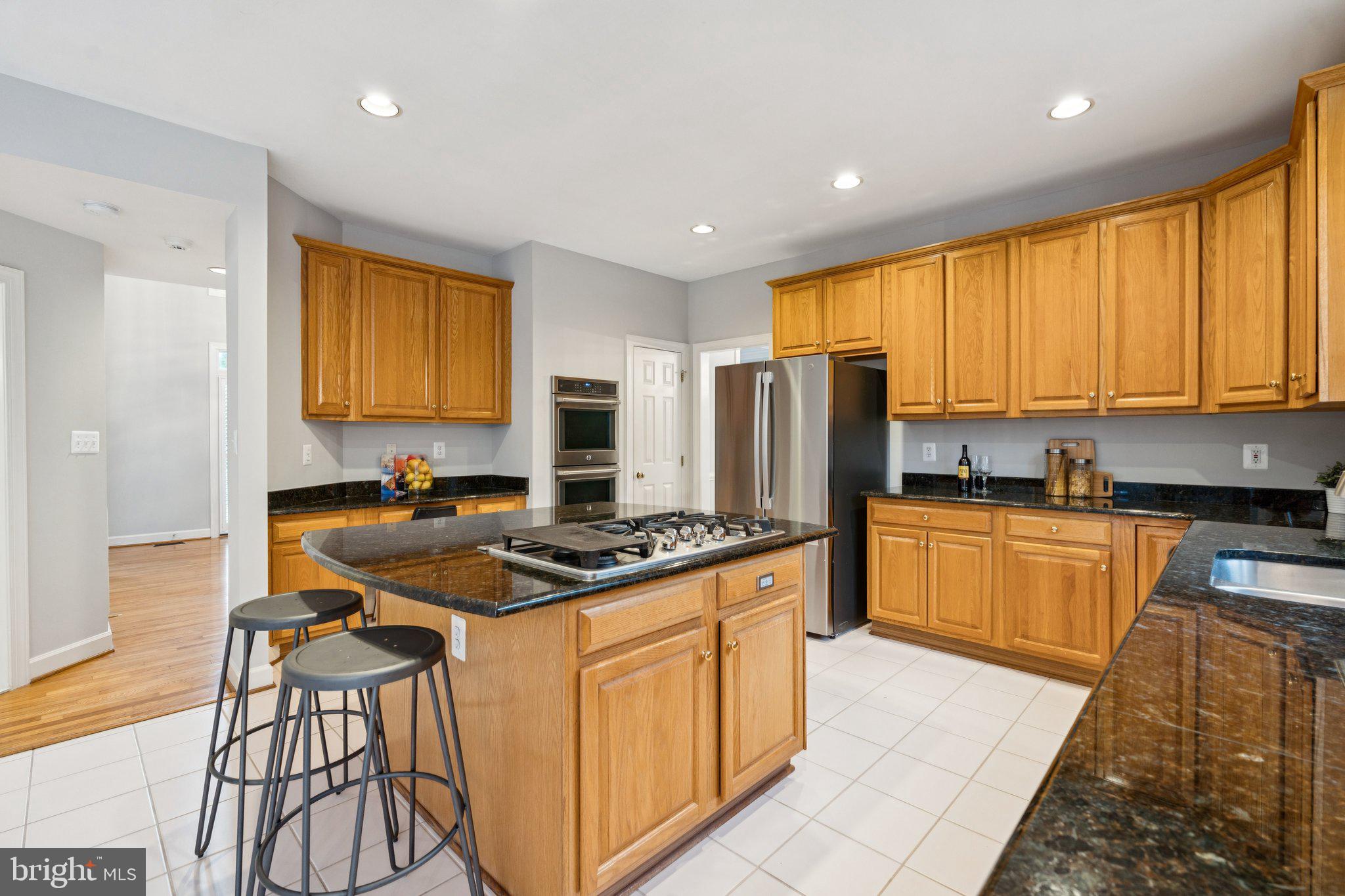 12213 Windsor Hall Way Herndon, VA 20170 - Photo 18 of 64 a kitchen with stainless steel appliances granite countertop a stove a sink a refrigerator and island