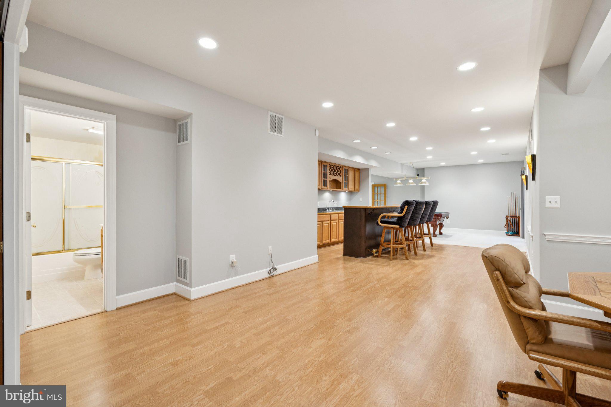 12213 Windsor Hall Way Herndon, VA 20170 - Photo 55 of 64 a view of a kitchen with a dining table chairs and couches with wooden floor