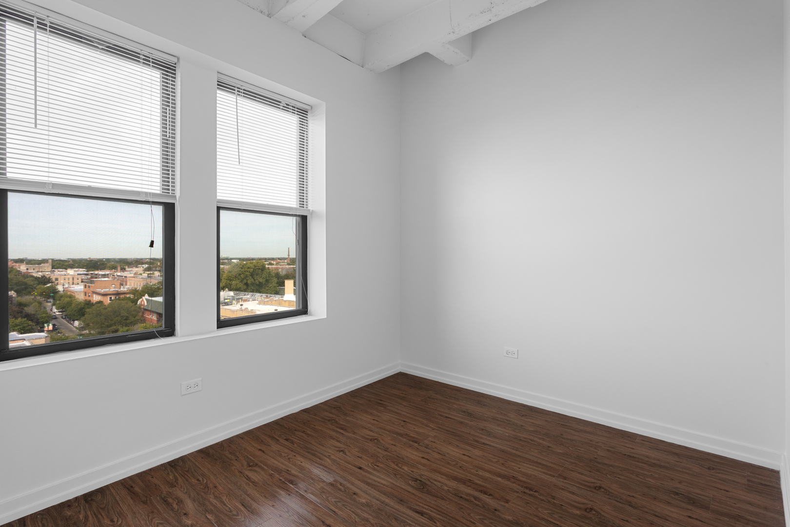 1325 West Wilson Avenue, Unit 1011 Chicago, IL 60640 - Photo 8 of 22 an empty room with wooden floor and windows