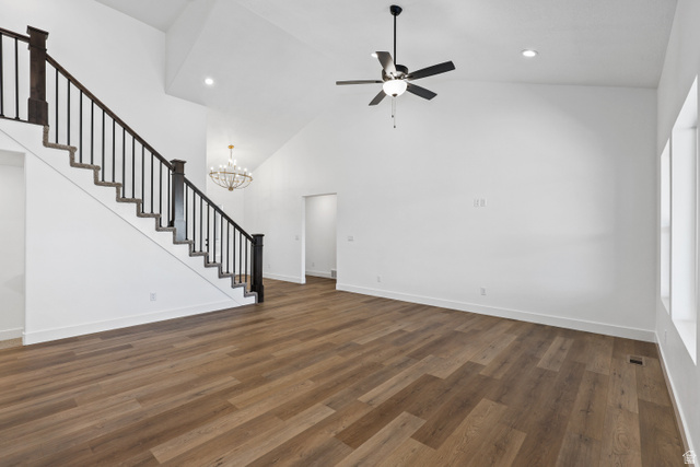 1139 South 4475 West West Point, UT 84015 - Photo 6 of 33 Unfurnished living room with dark wood-type flooring, high vaulted ceiling, stairs, ceiling fan, and a chandelier