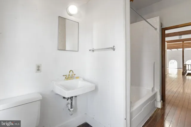 an empty room with wooden floor and window