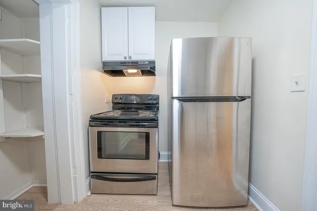 a white refrigerator freezer and a stove sitting inside of a kitchen