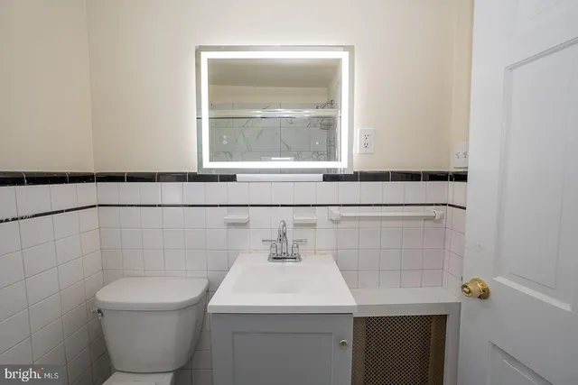 a bathroom with a toilet sink and mirror