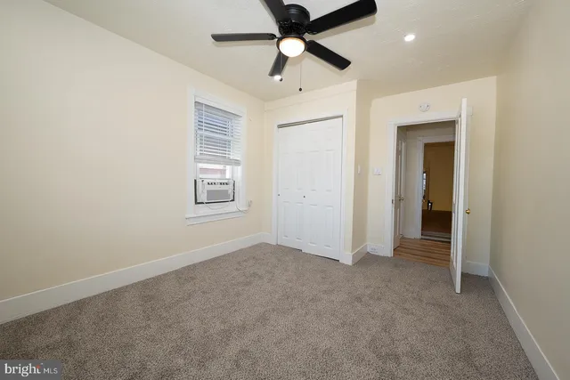 an empty room with fan and windows