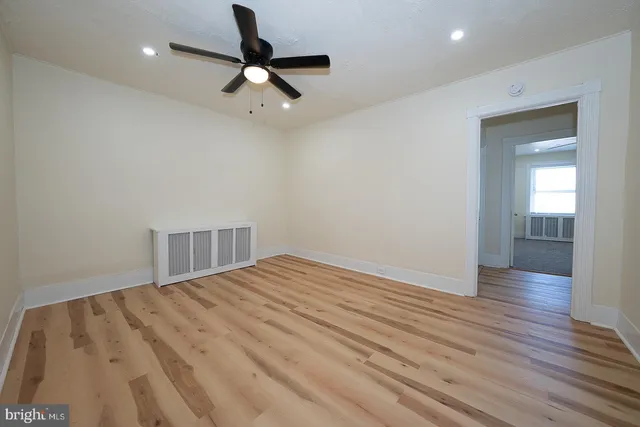 a view of empty room with wooden floor