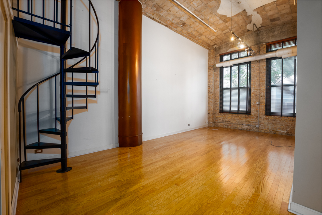 801 South Wells Street, Unit 102 Chicago, IL 60607 - Photo 14 of 26 a view of an empty room with wooden floor and stairs