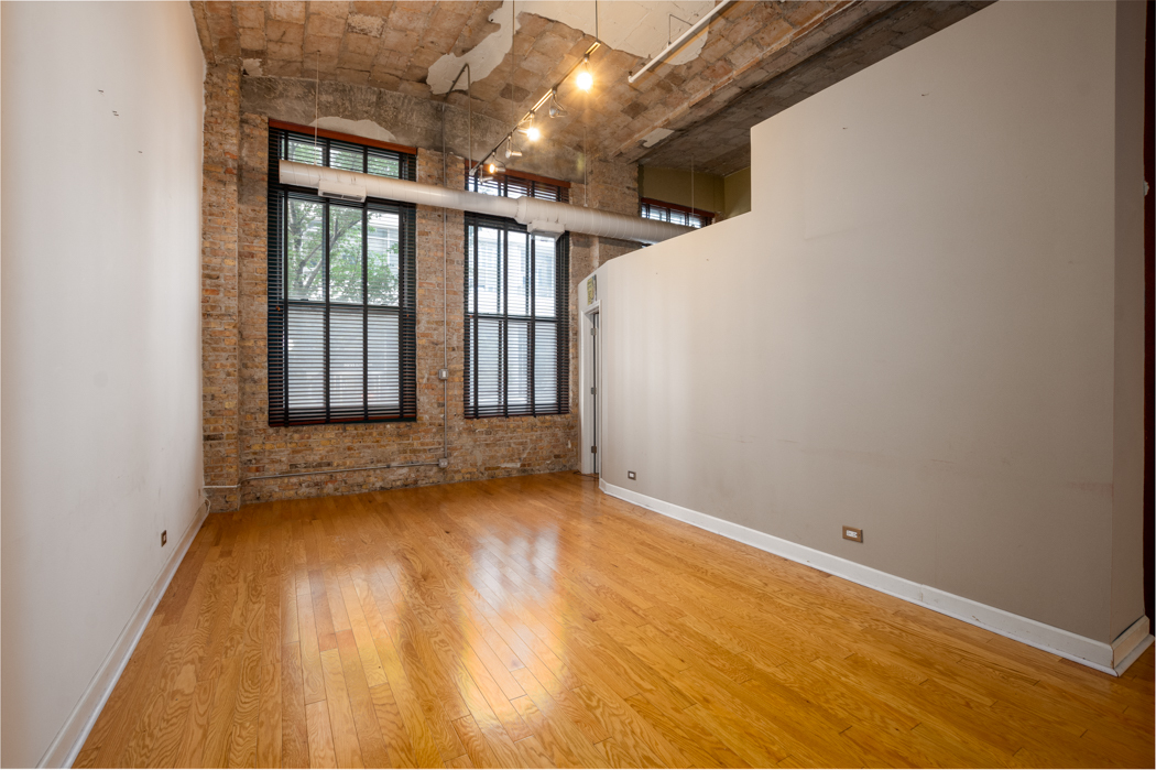 801 South Wells Street, Unit 102 Chicago, IL 60607 - Photo 15 of 26 an empty room with wooden floor and windows