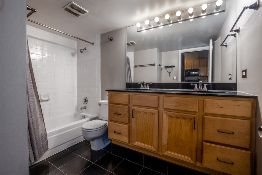 801 South Wells Street, Unit 102 Chicago, IL 60607 - Photo 17 of 26 a bathroom with a double vanity sink a toilet a mirror and shower