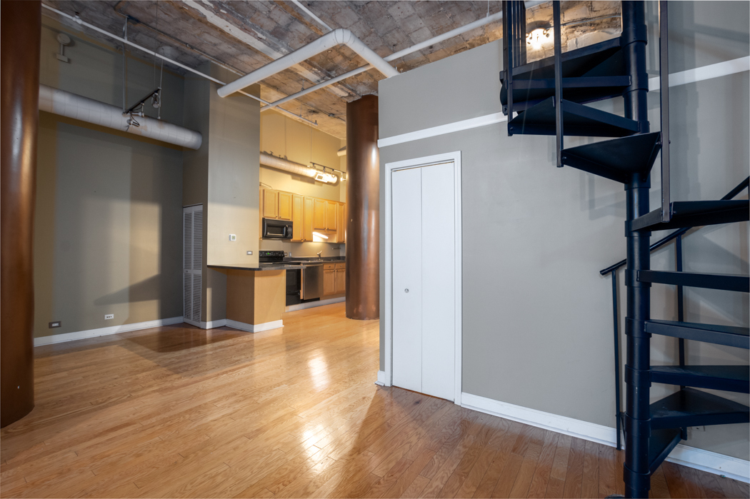 801 South Wells Street, Unit 102 Chicago, IL 60607 - Photo 21 of 26 an empty room with wooden floor and windows