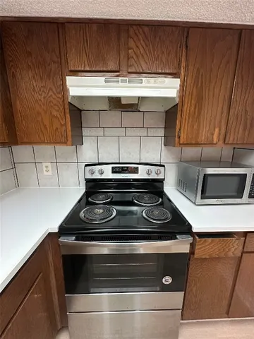 a stove top oven sitting inside of a kitchen