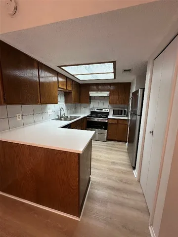 a kitchen with stainless steel appliances a sink stove and refrigerator