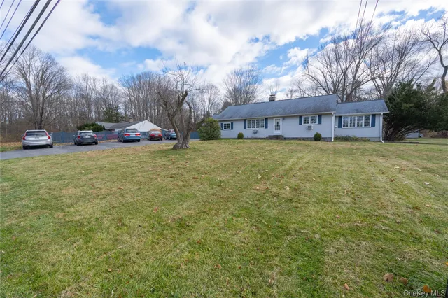 a view of a house with a yard and sitting area