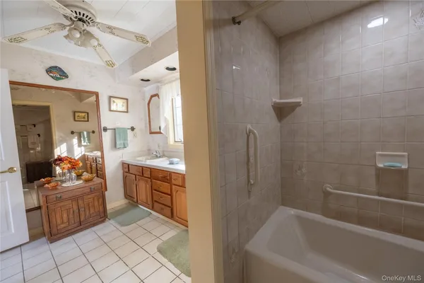 a bathroom with a tub sink and mirror