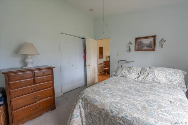 a bedroom with a bed and a lamp on dresser