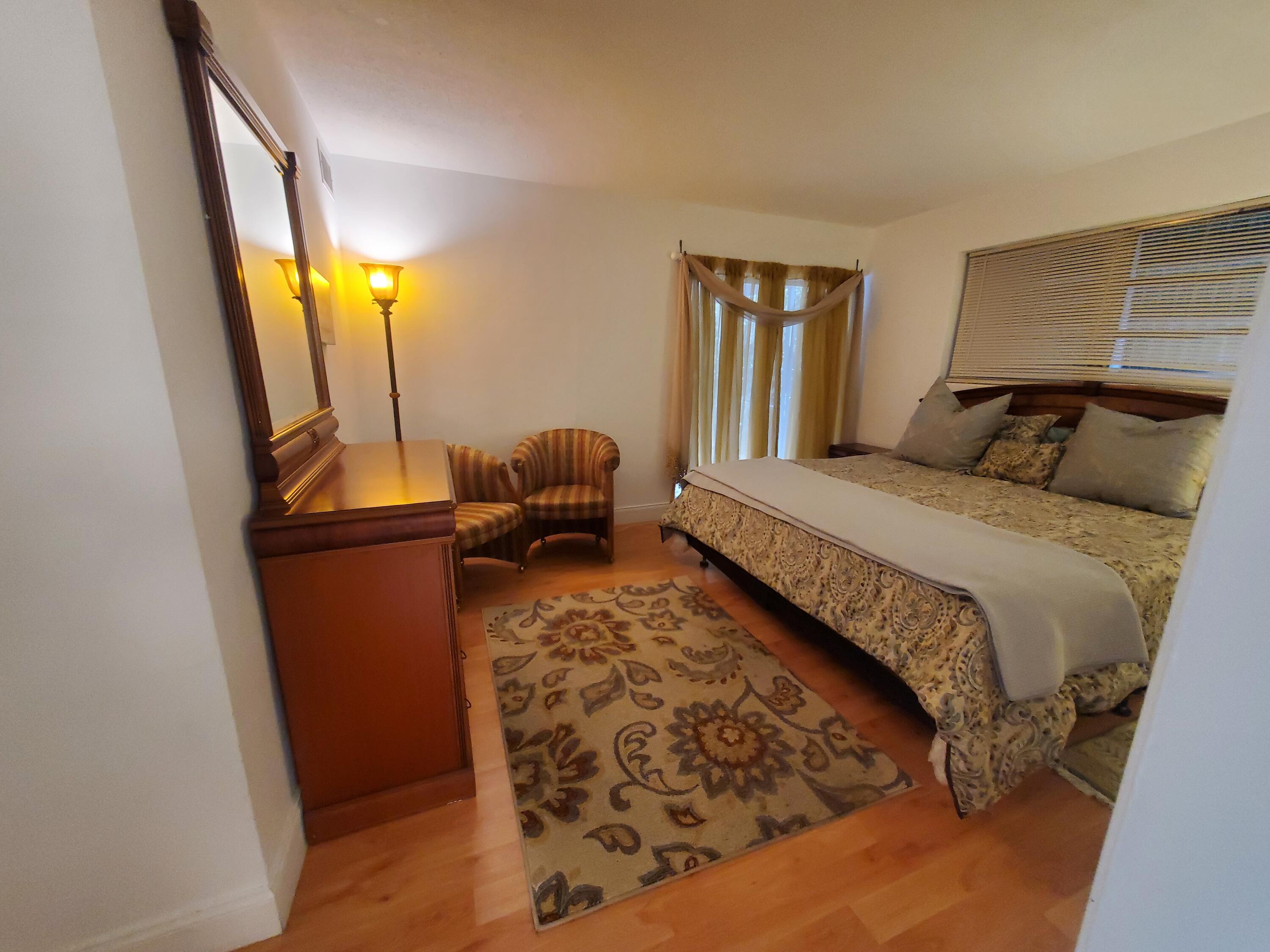 20 Southeast 13th Street, Unit A6 Boca Raton, FL 33432 - Photo 6 of 14 a bedroom with a bed and wooden floor