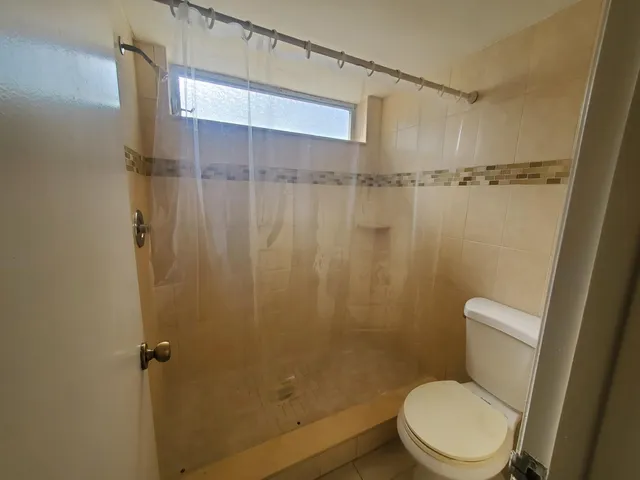 a white toilet sitting next to a shower