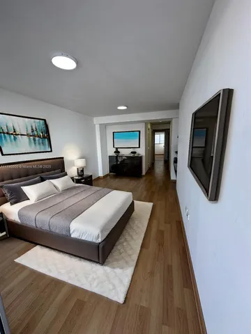 a spacious bedroom with a bed and a television